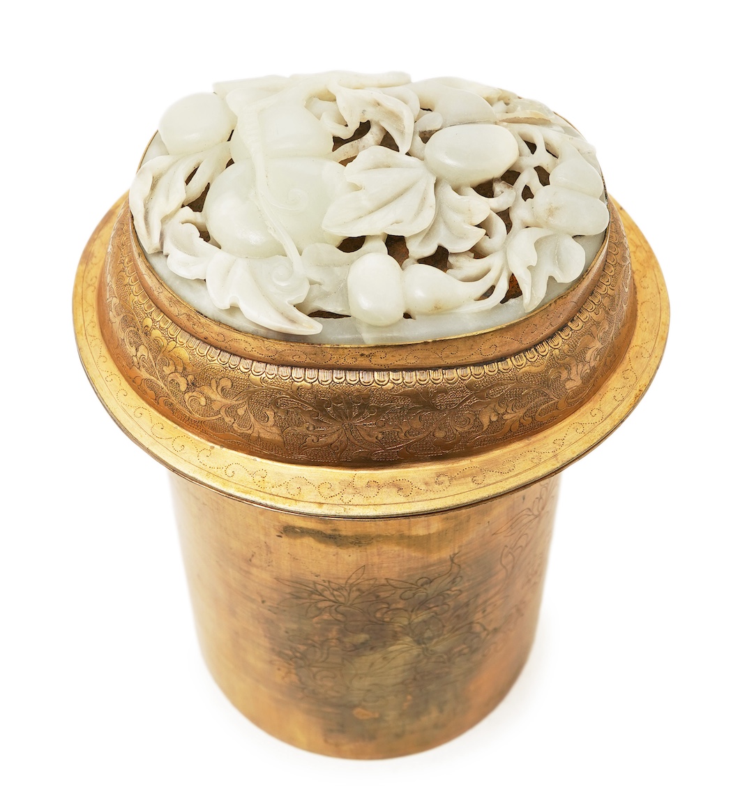 A Chinese pale celadon jade oval plaque, 17th/18th century, mounted on a late Qing gilt copper jar